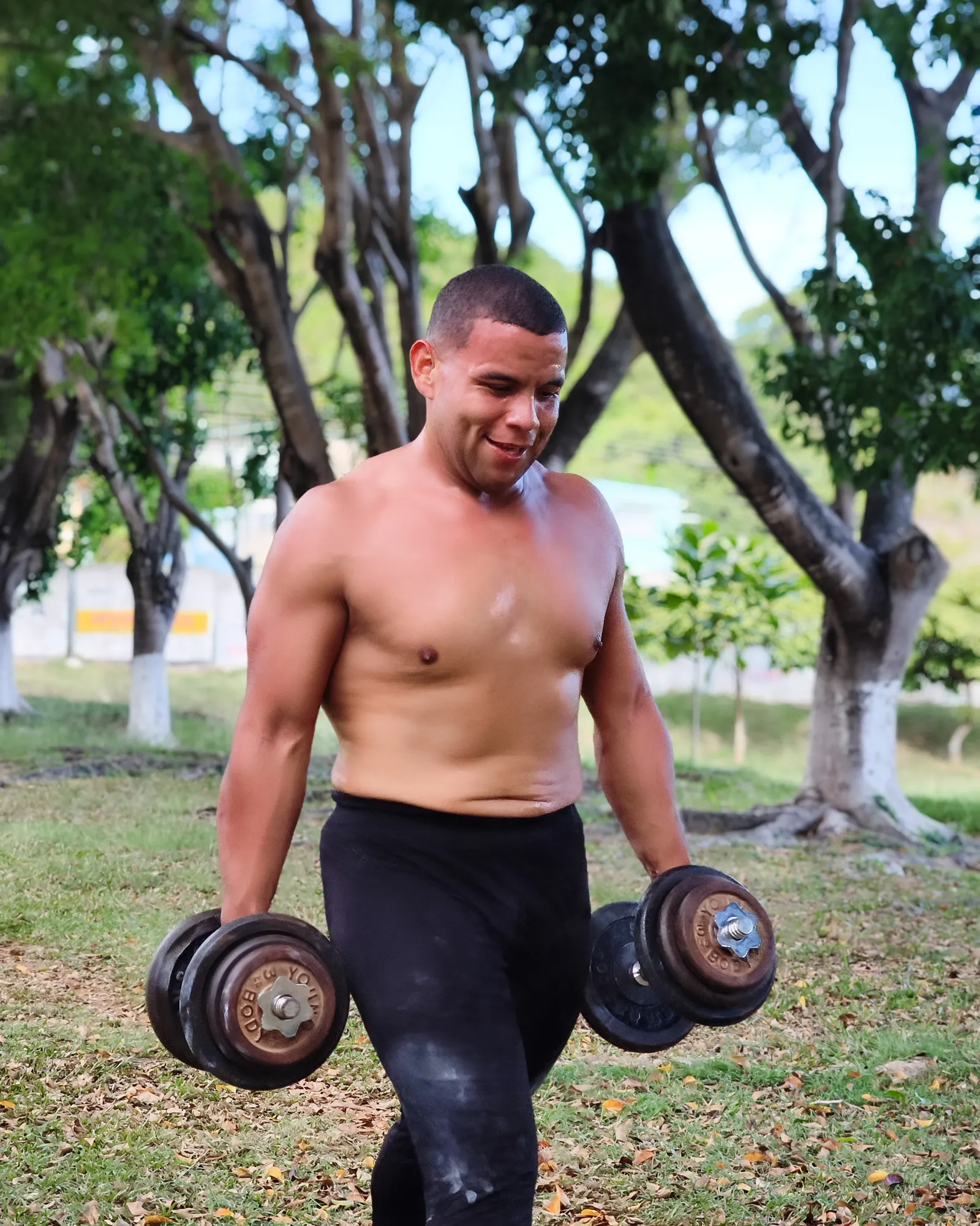 Participante carga un par de mancuernas mientras camina durante el circuito del FitClub Fest.